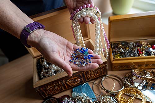 jewelry boxes and a hand holding valuable jewelry